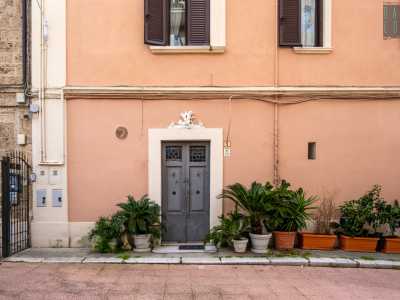 ...veglia su un ingresso secondario, costituito da una porticina grigia